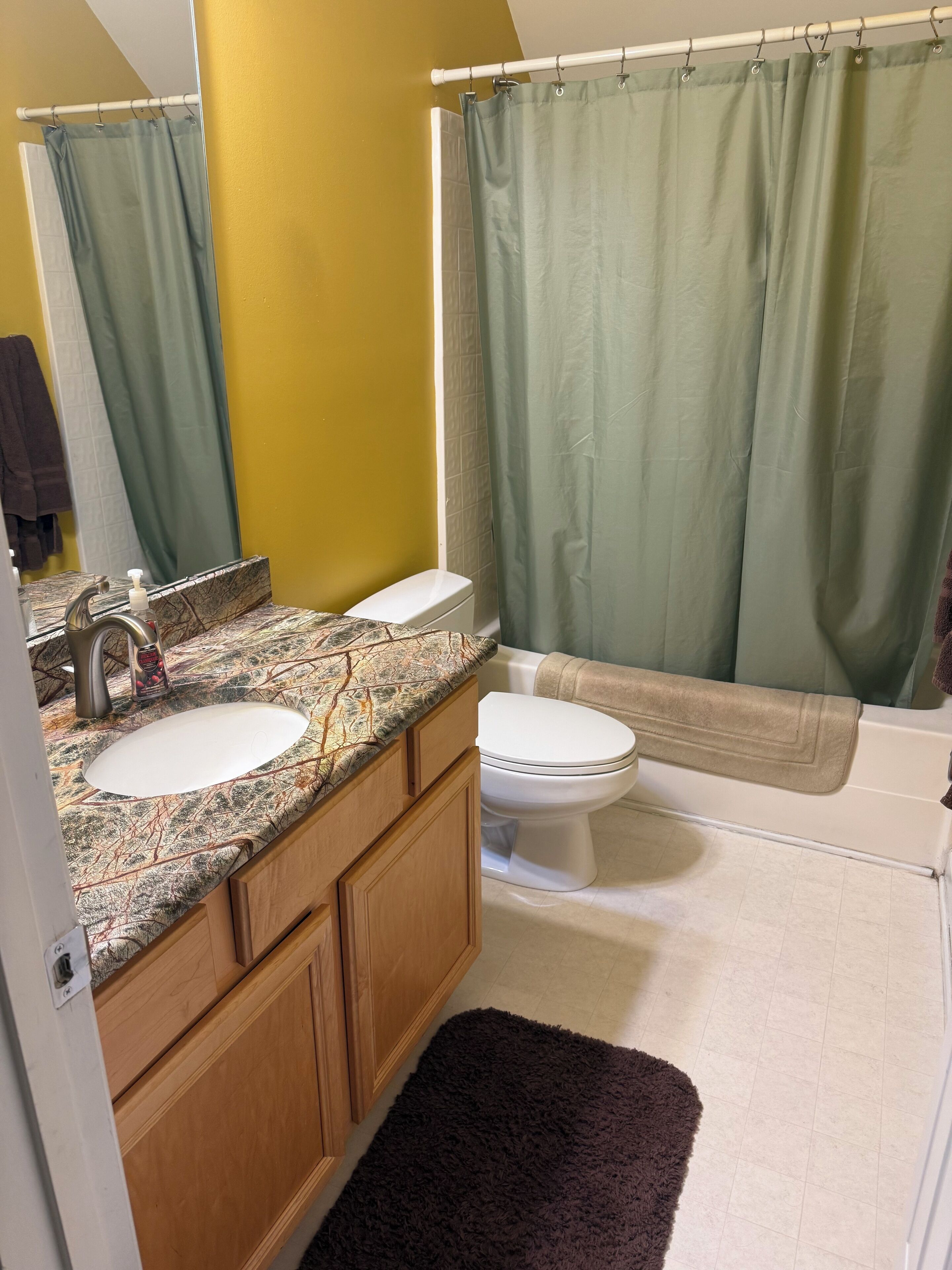 A bathroom with a white sink, a toilet, and a bathtub.