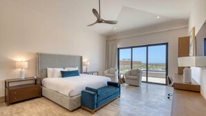 Une chambre d’hôtel moderne dotée d’un grand lit, d’un ventilateur de plafond, d’un bureau, d’une chaise et offrant une vue sur l’extérieur.