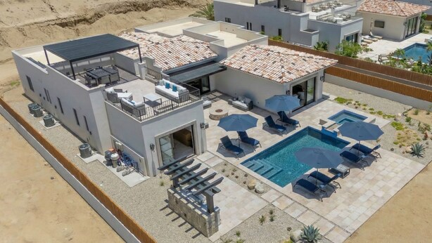 Un complexe hôtelier moderne doté d’une piscine sur le toit, d’un espace extérieur aménagé et d’un jardin bien entretenu.