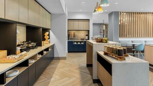 A modern kitchen with a central island, wooden cabinets, and pendant lighting. - Towneplace Suites By Marriott Youngstown North (Girard)