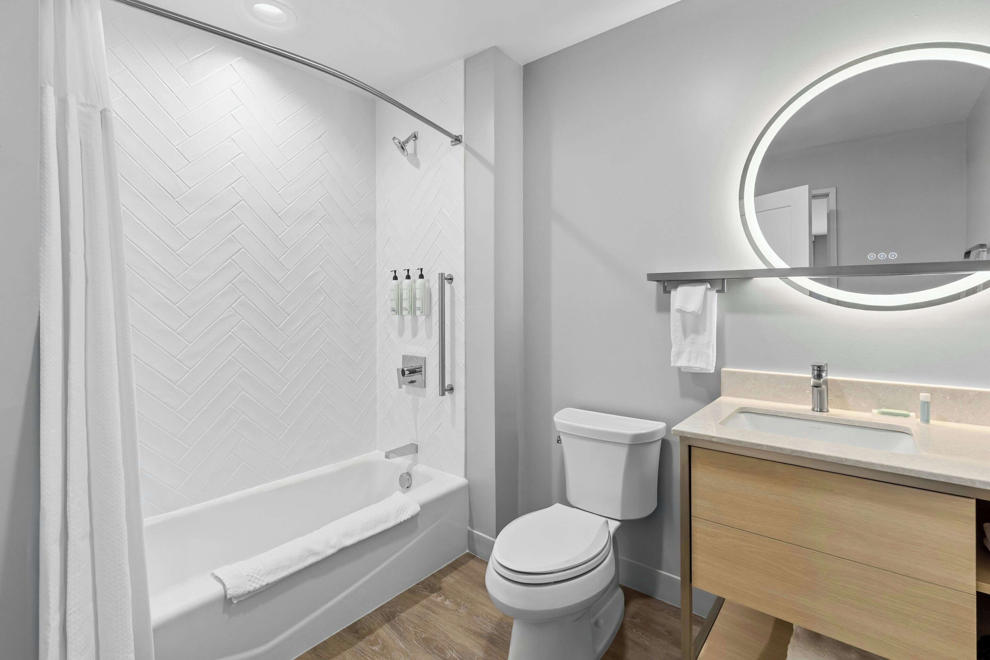 Un baño moderno con bañera, inodoro y tocador.