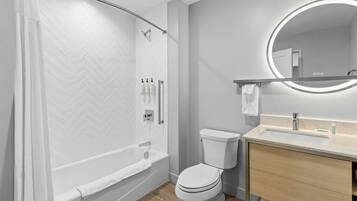 Un baño moderno con bañera, inodoro y tocador.
