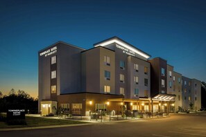 A multi-story hotel with a modern design, featuring a well-lit entrance and a covered outdoor area. - Towneplace Suites By Marriott Youngstown North (Girard)