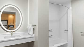 Une salle de bain moderne avec un lavabo blanc, un miroir doté d’un éclairage circulaire et une douche avec un rideau blanc.