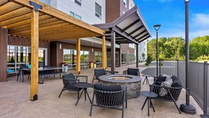 An outdoor patio with a fire pit, seating, and a covered area. - Towneplace Suites By Marriott Youngstown North (Girard)