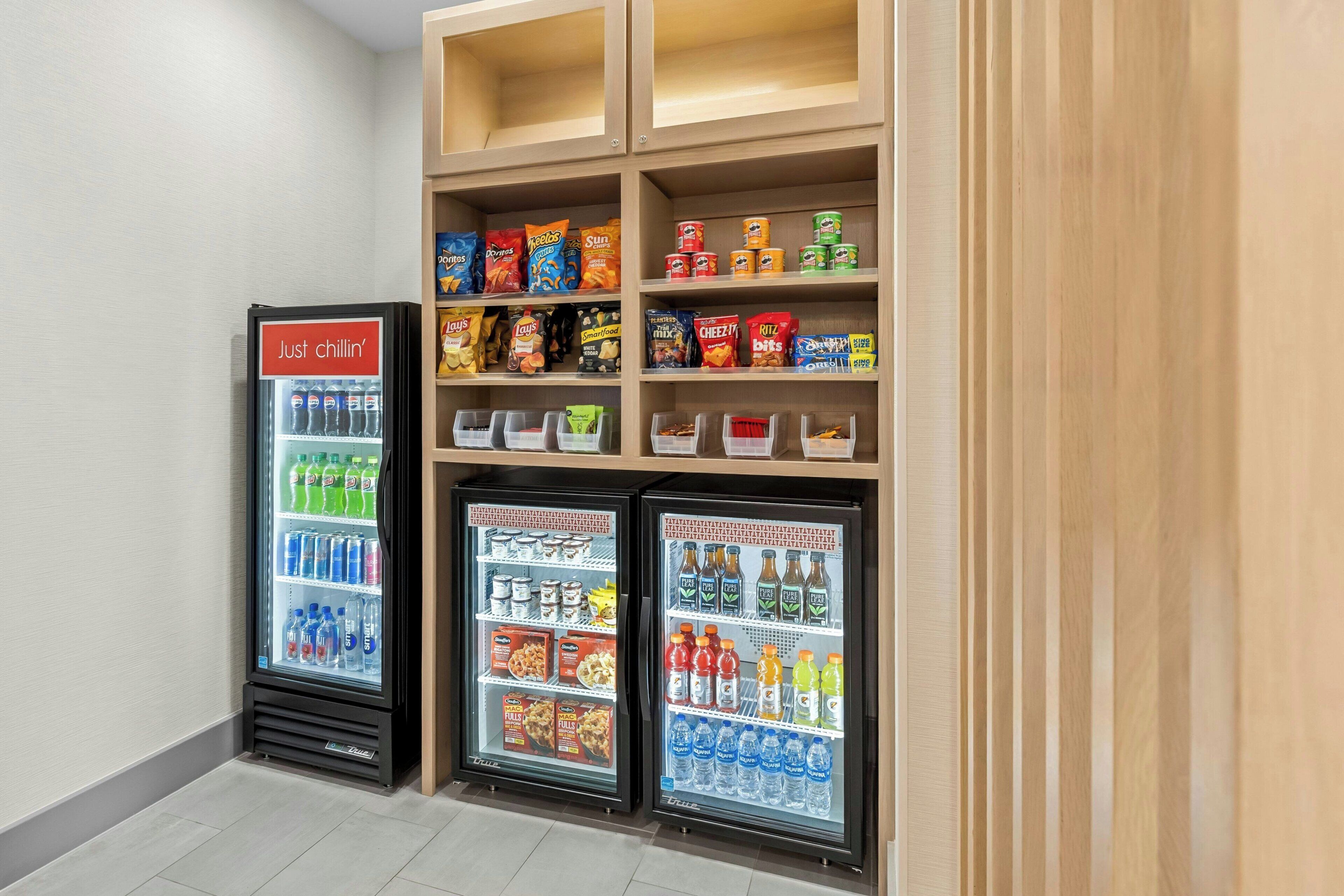 A vending area with snacks and drinks, including a 'Just chillin'' cooler and a 'Sun' cooler.
