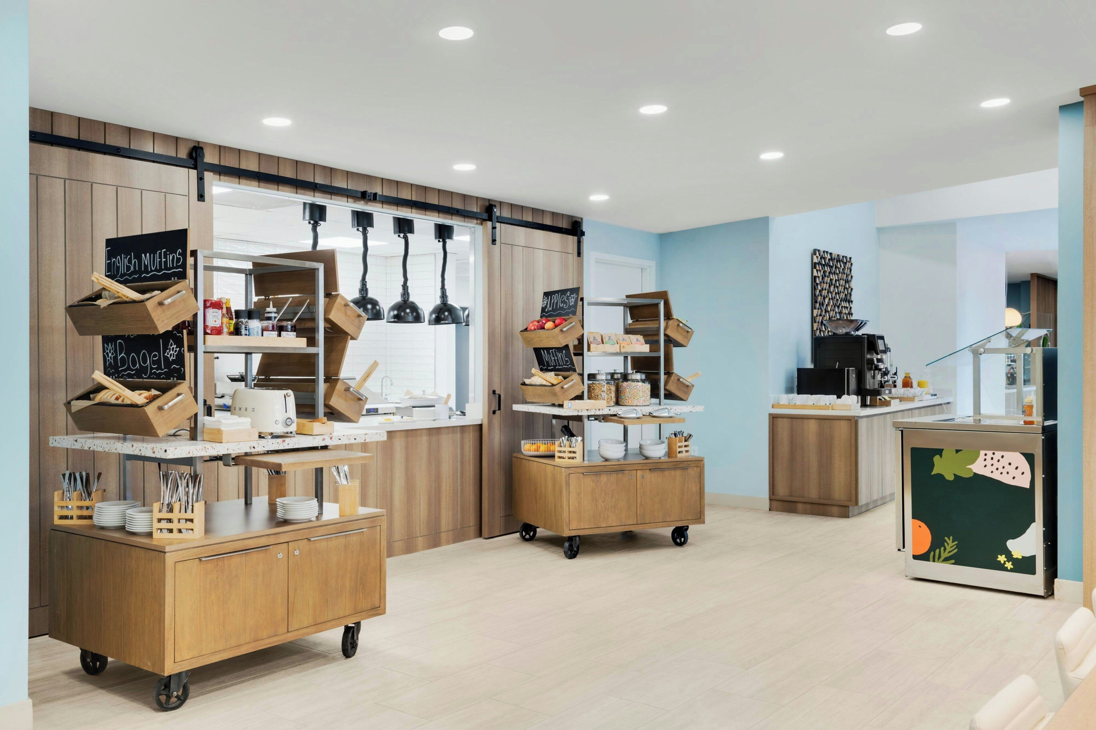 Una cocina moderna con armarios de madera, una isla central y un menú en pizarra.