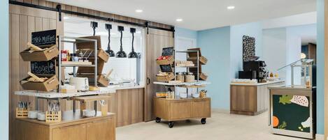 Una cocina moderna con armarios de madera, una isla central y un menú en pizarra.