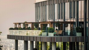 A modern building with a glass balcony and outdoor seating area. - Paragraph Golf & Spa Tabori, Autograph Collection (Tbilisi)