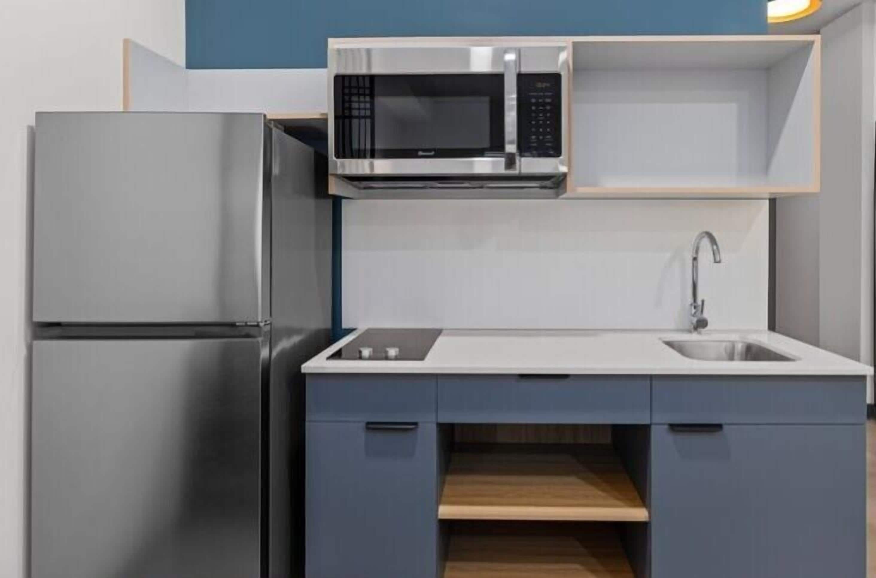 Een koelkast met diepvriezer, een microgolfoven, een kookplaat