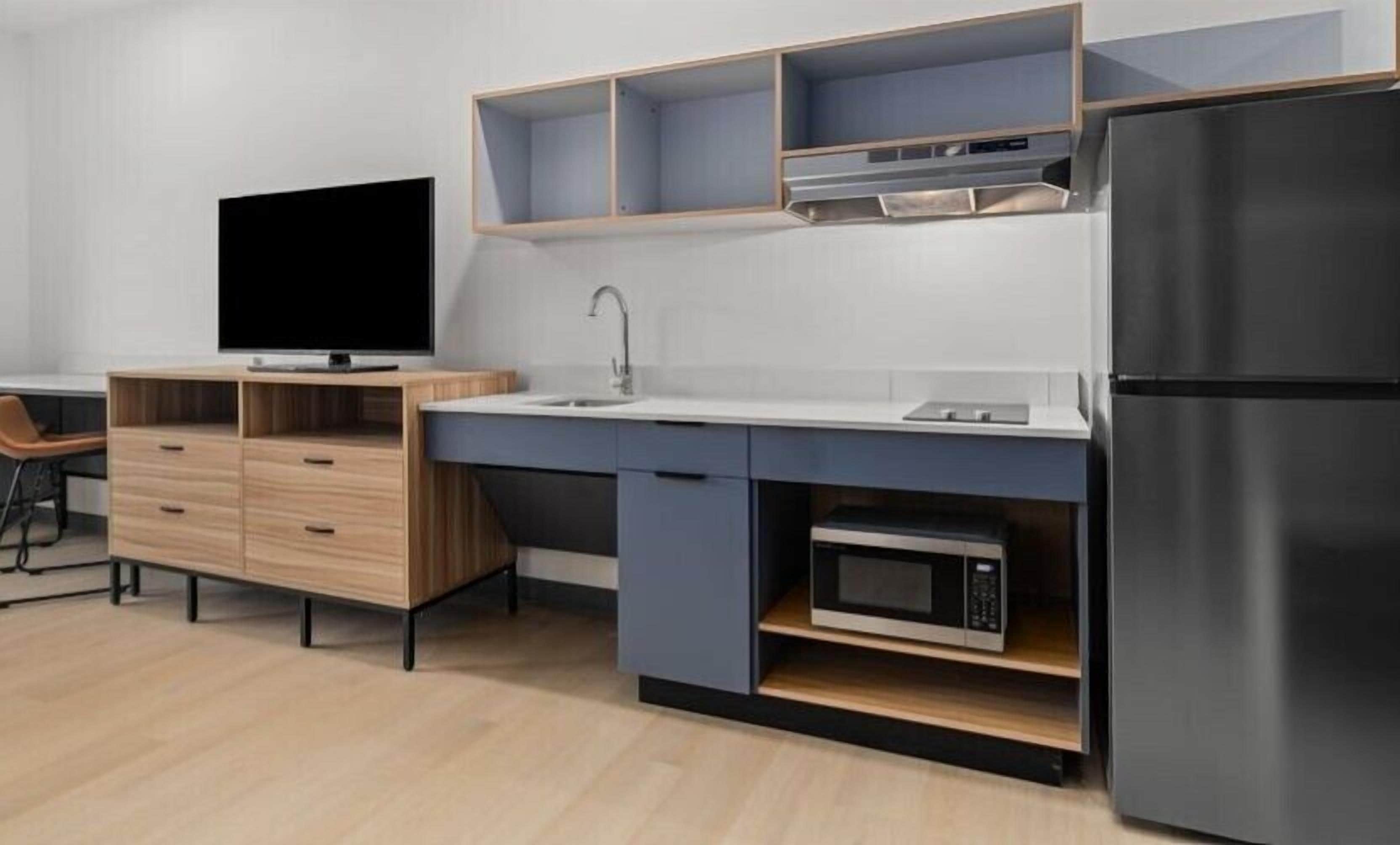 Een koelkast met diepvriezer, een microgolfoven, een kookplaat