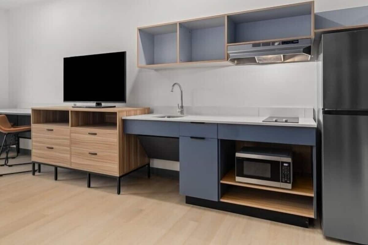 Een koelkast met diepvriezer, een microgolfoven, een kookplaat