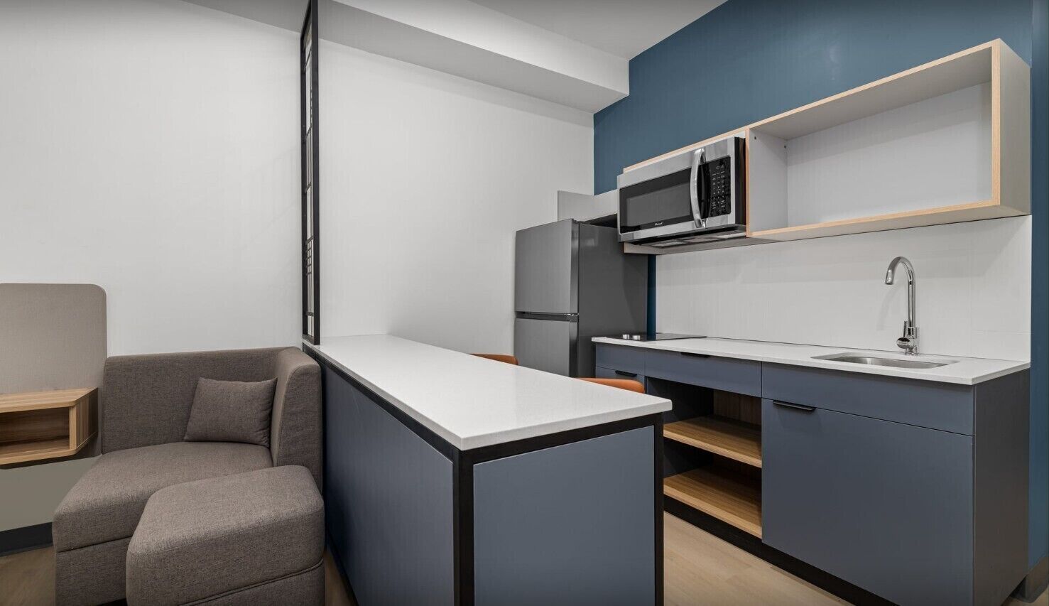 A modern kitchen with a built-in microwave, a refrigerator, and a sink.