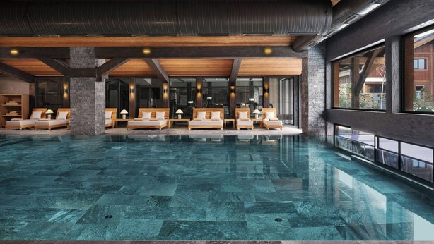 Une piscine intérieure spacieuse, dotée d’une eau cristalline, de coins détente en bois et de grandes fenêtres offrant une vue sur l’extérieur.