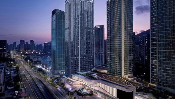 Un immeuble moderne de grande hauteur, reconnaissable à son panneau « Courtyard » bien visible, entouré d’autres bâtiments imposants dans un paysage urbain.