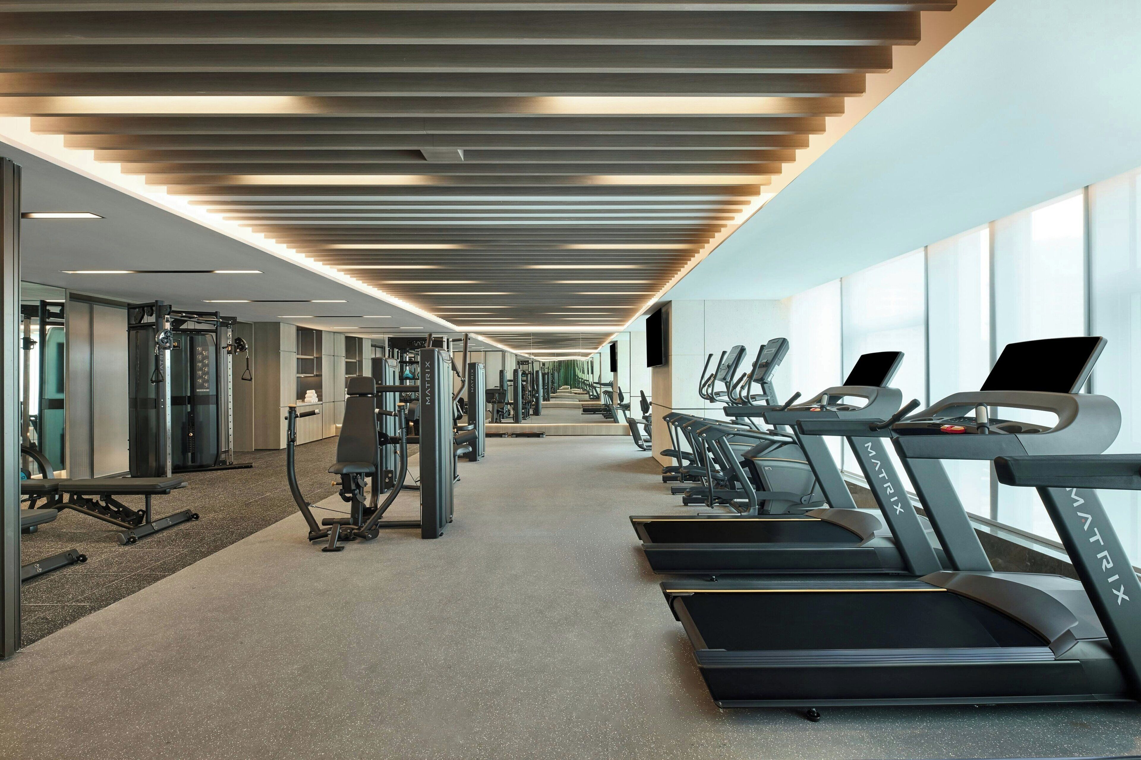 A modern gym with treadmills, weight machines, and a spacious layout.