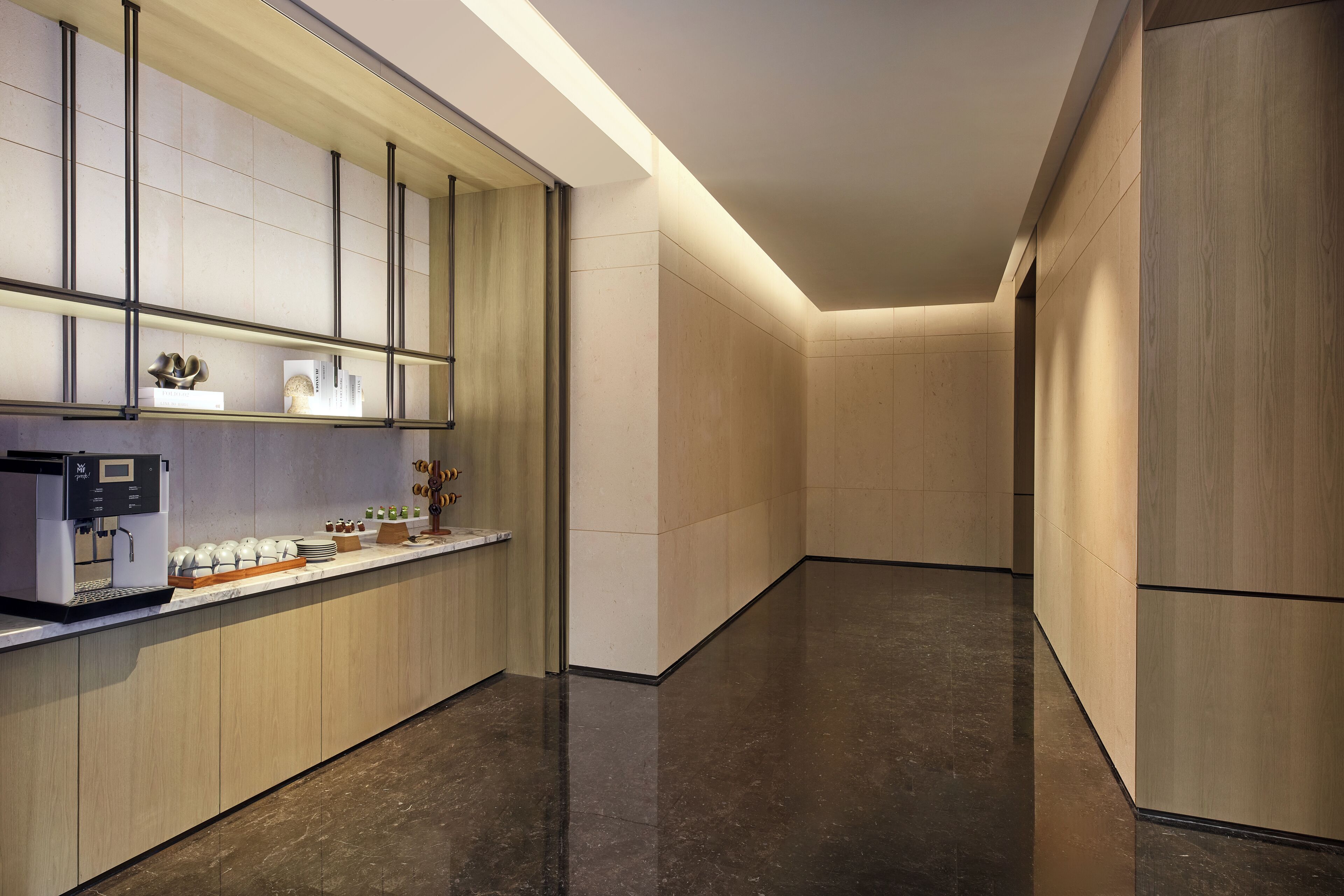Una cocina moderna con cafetera, encimera con diversos objetos y un diseño elegante.
