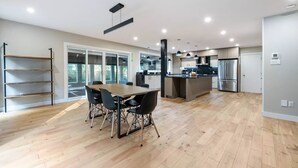 Eine geräumige Küche mit Essbereich, Holzboden und modernen Geräten.