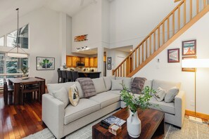 Ein geräumiges Wohnzimmer mit einer großen Couch, einem Couchtisch und einer Treppe.