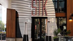 Ein modernes Gebäude mit einer markanten, gestreiften Fassade, auf der die Buchstaben "STK" gut sichtbar sind.