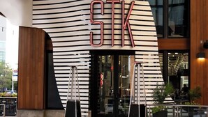 A modern building with a unique curved facade and the letters "STK" prominently displayed above the entrance.