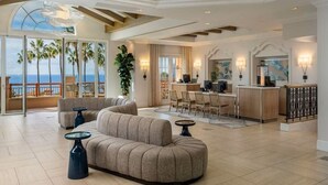 A spacious living area with a large sofa, a dining table, and a kitchen area.