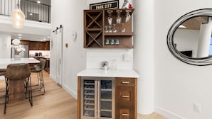 A modern kitchen with a white countertop, wooden cabinets, and a built-in wine rack.