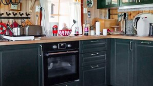 A kitchen with dark green cabinets, a built-in oven, and various kitchen appliances. - 3 bedroom beautiful home in Tynset (Tynset)