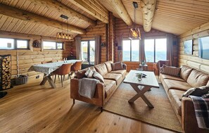 A log cabin interior with a dining area, sofas, and a fireplace. - Nice home in Gol with sauna (Gol)