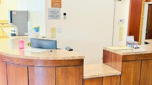 Una recepción con un cartel de registro, una planta y una lámpara de escritorio.