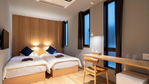 A modern hotel room with two beds, a desk, and a small refrigerator. - ZONE SHINSAIBASHI WEST (Osaka)