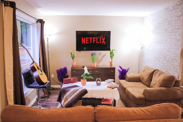 A fully equipped living room with a smart TV, Guitar and ample mini games