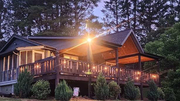 A wooden cabin with a balcony, surrounded by trees. - Dog-Kids and Family Friendly Riverfront Cabin! (Crumpler)