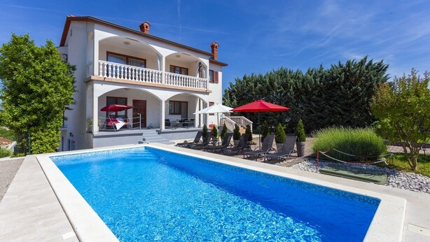 Un bâtiment à deux étages doté d’une piscine, d’un espace extérieur aménagé et d’un jardin bien entretenu.