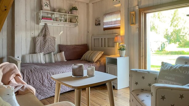 Une pièce confortable avec un lit, une table de chevet, une chaise et une table.