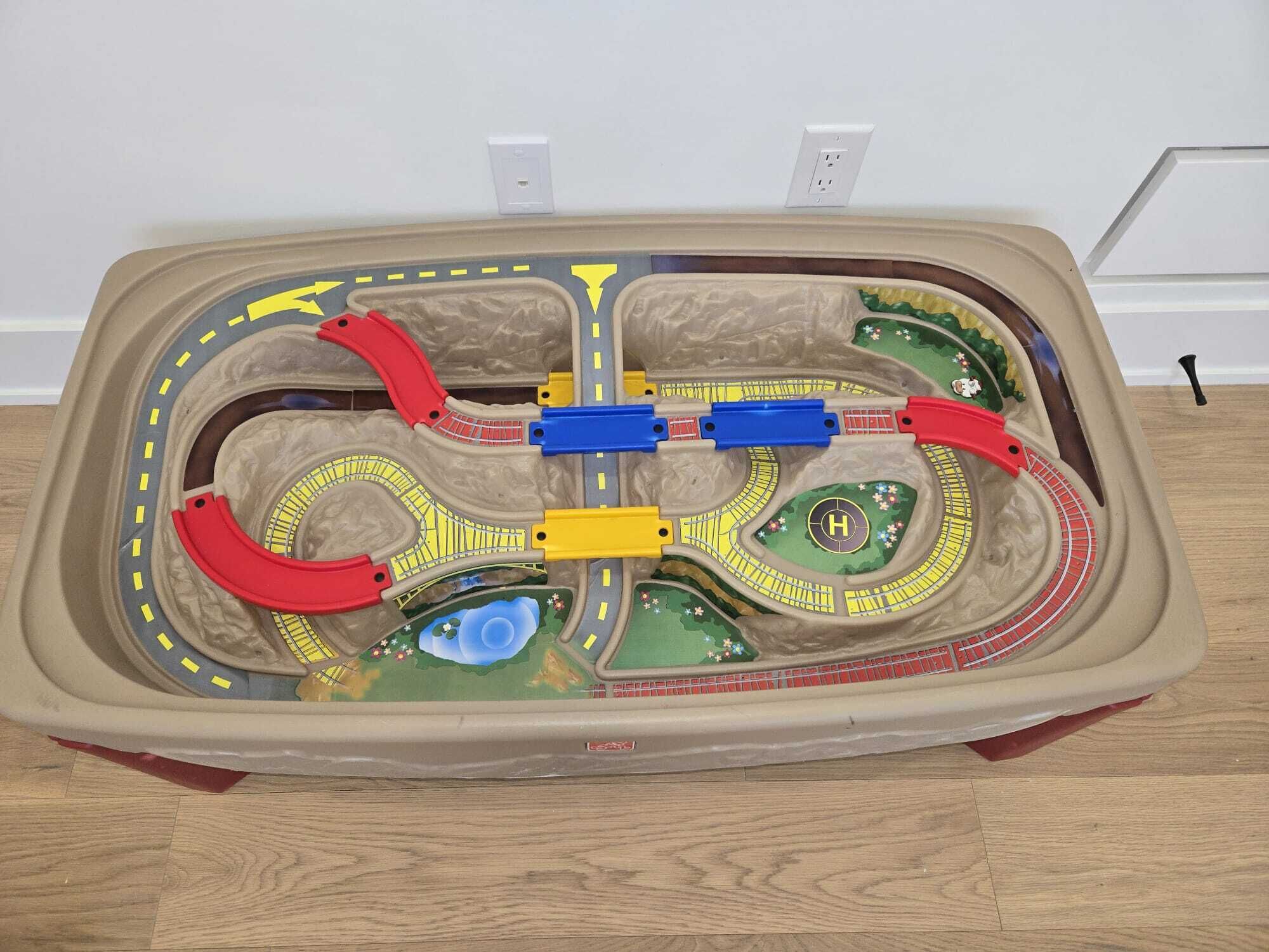 Een modelbaan met meerdere sporen en een centraal station.
