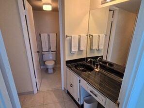 A bathroom with a black sink, white toilet, and a mirror. - Amazing Beachfront & River Views! 2BD/2BA @ Peck 20SW (Daytona Beach Shores)