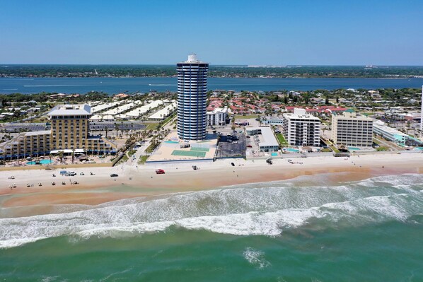 A coastal cityscape with a prominent tall hotel, a beach, and a marina. - Amazing Beachfront & River Views! 2BD/2BA @ Peck 20SW (Daytona Beach Shores)