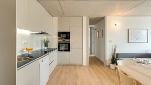 A modern kitchen with white cabinetry, a black countertop, and a built-in oven. - Balcony 2BRs with Pool & Parking by HostWise (Vila Nova de Gaia)