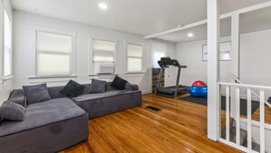 A modern living room with a sectional sofa, a treadmill, and exercise balls. - Perfect Group Stay! See the Stunning Social Area X6 (Grandview)