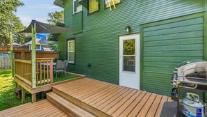 A green house with a wooden deck, a barbecue grill, and a small outdoor seating area. - Perfect Group Stay! See the Stunning Social Area X6 (Grandview)