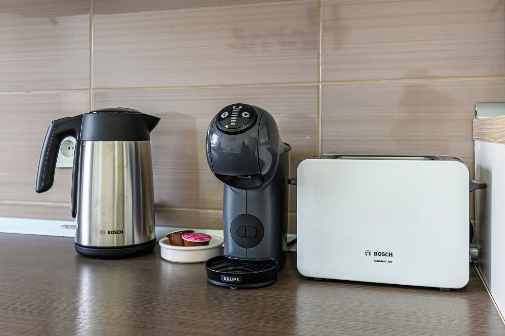 Una cucina con una macchina da caffè Bosch, un bollitore e un tostapane sul piano di lavoro.