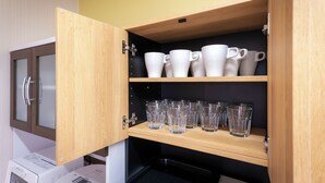 Eine Küche mit Holzschränken, einer Mikrowelle und einer Kaffeemaschine.