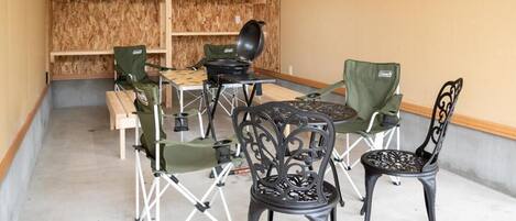A dining area with a round table, four chairs, and a portable grill.
