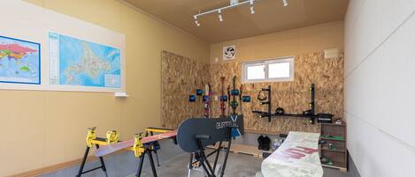 Quarto com parede de madeira, um mapa, uma prancha de snowboard e um suporte para pranchas.