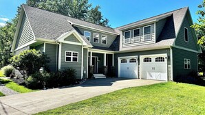 A two-story house with a front porch, a driveway, and a garage.