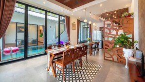A spacious dining area with a pool view, wooden furniture, and a decorative partition. - 6BRs w/ Private Pool & Billiard - 7min to Beach (Thành phố Hội An)