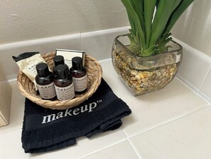A bathroom with a black towel labeled "makeup" and a glass bowl containing a plant and pebbles. - Spacious Beachside Condo in Cocoa Beach, Florida! 125 Feet to Beach! (Cocoa Beach)