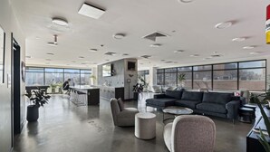 A spacious office with a modern kitchen, seating area, and large windows offering city views. - Boutique Studio with Rooftop View and Gym (Philadelphia)