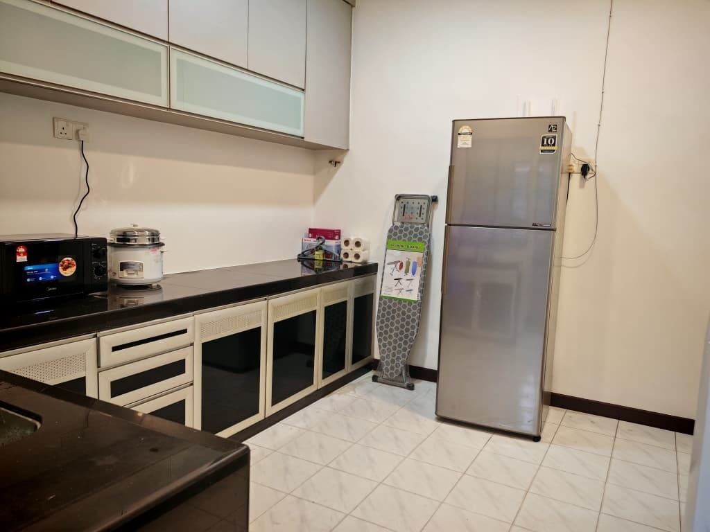A kitchen with a refrigerator, microwave, and cabinets.